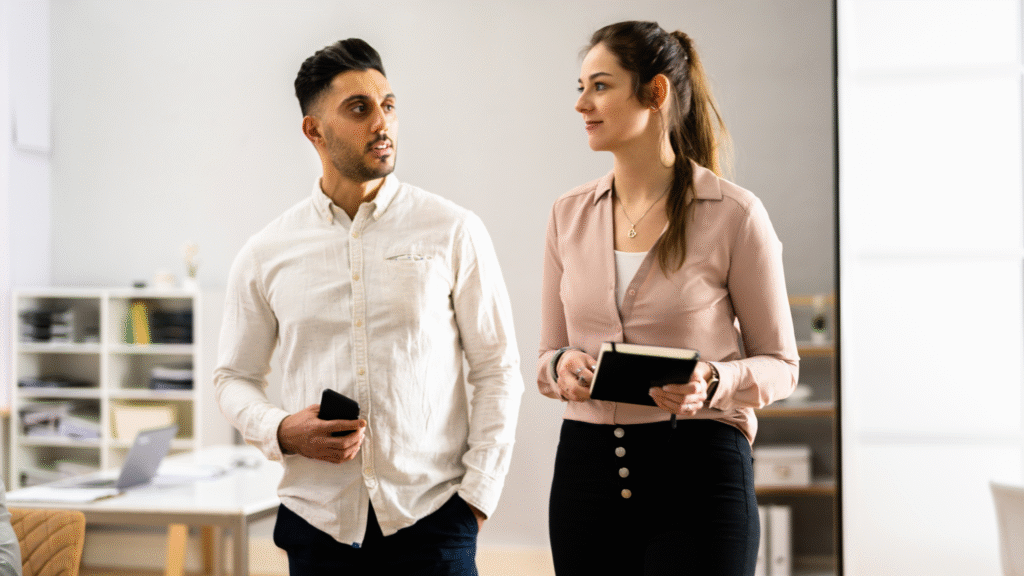 Two employees walking through the office, engaged in conversation