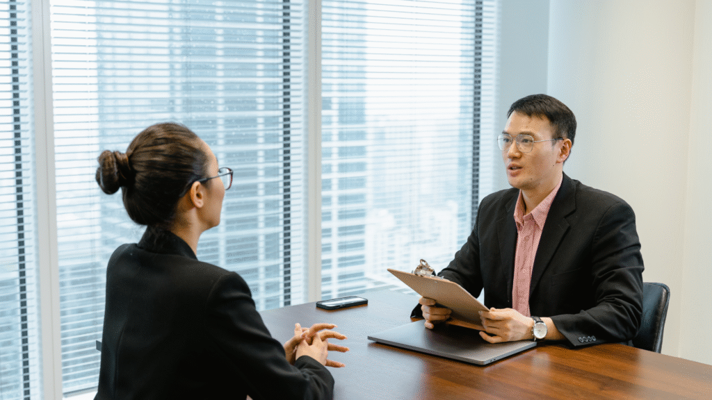 Manager and employee having a one-on-one meeting with documents on the table