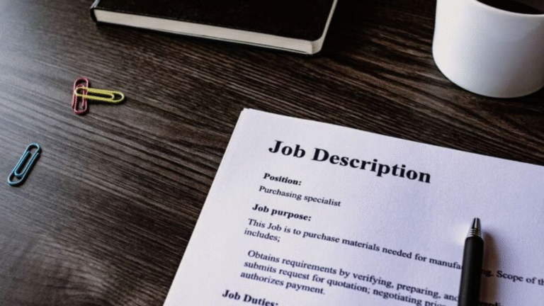 Job description document on a desk with paper clips, notebook, and a cup of coffee